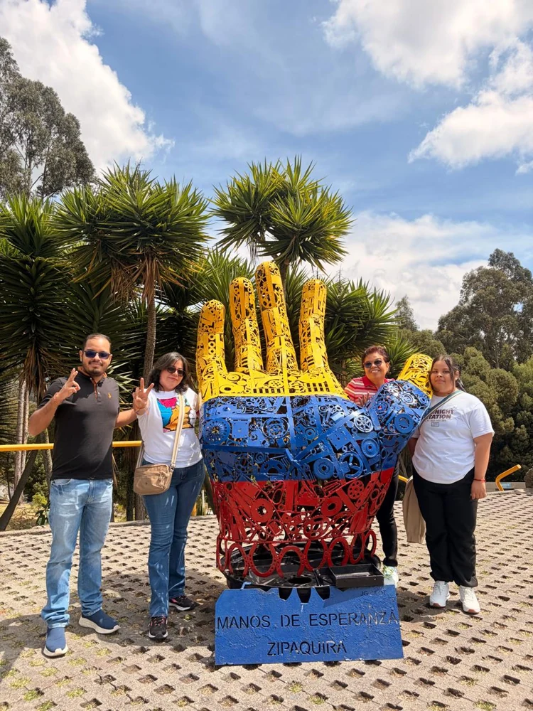 Viajeros junto a la escultura Manos de Esperanza en Zipaquirá